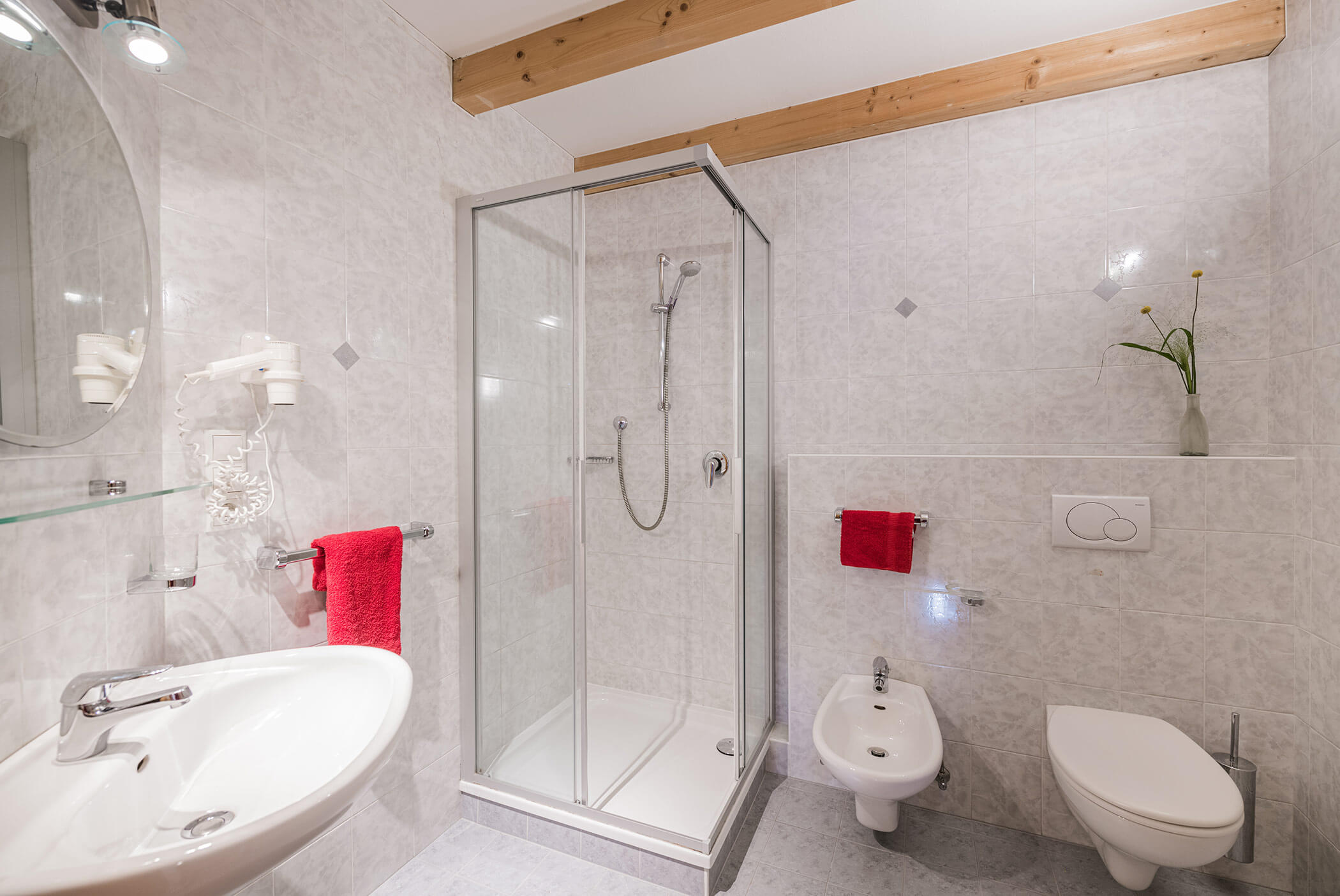 Bad mit WC, Dusche, Waschbecken und roten Handtüchern - Klaudehof