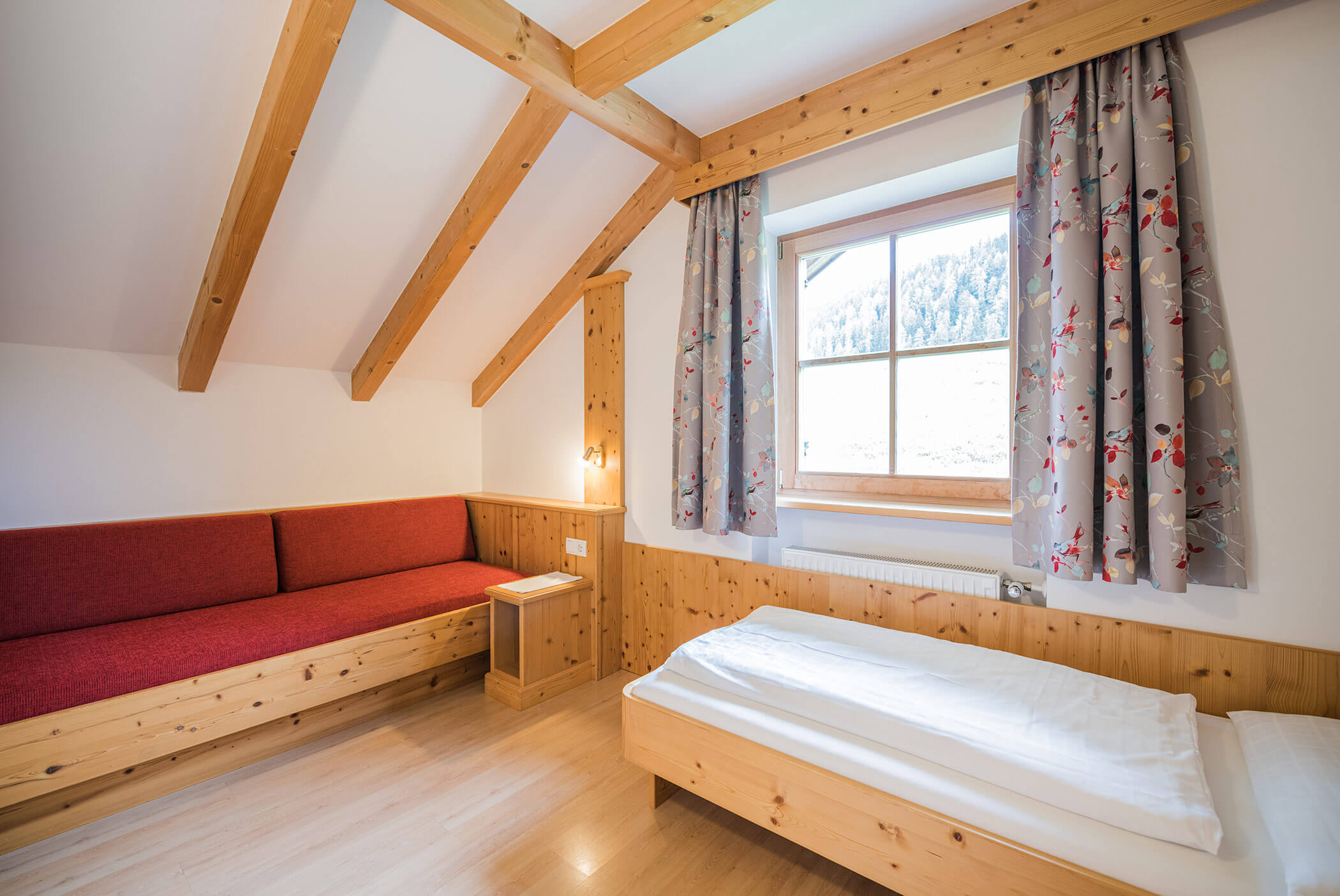 Einzelzimmer, darüber ein Fenster und daneben eine Bank - Klaudehof